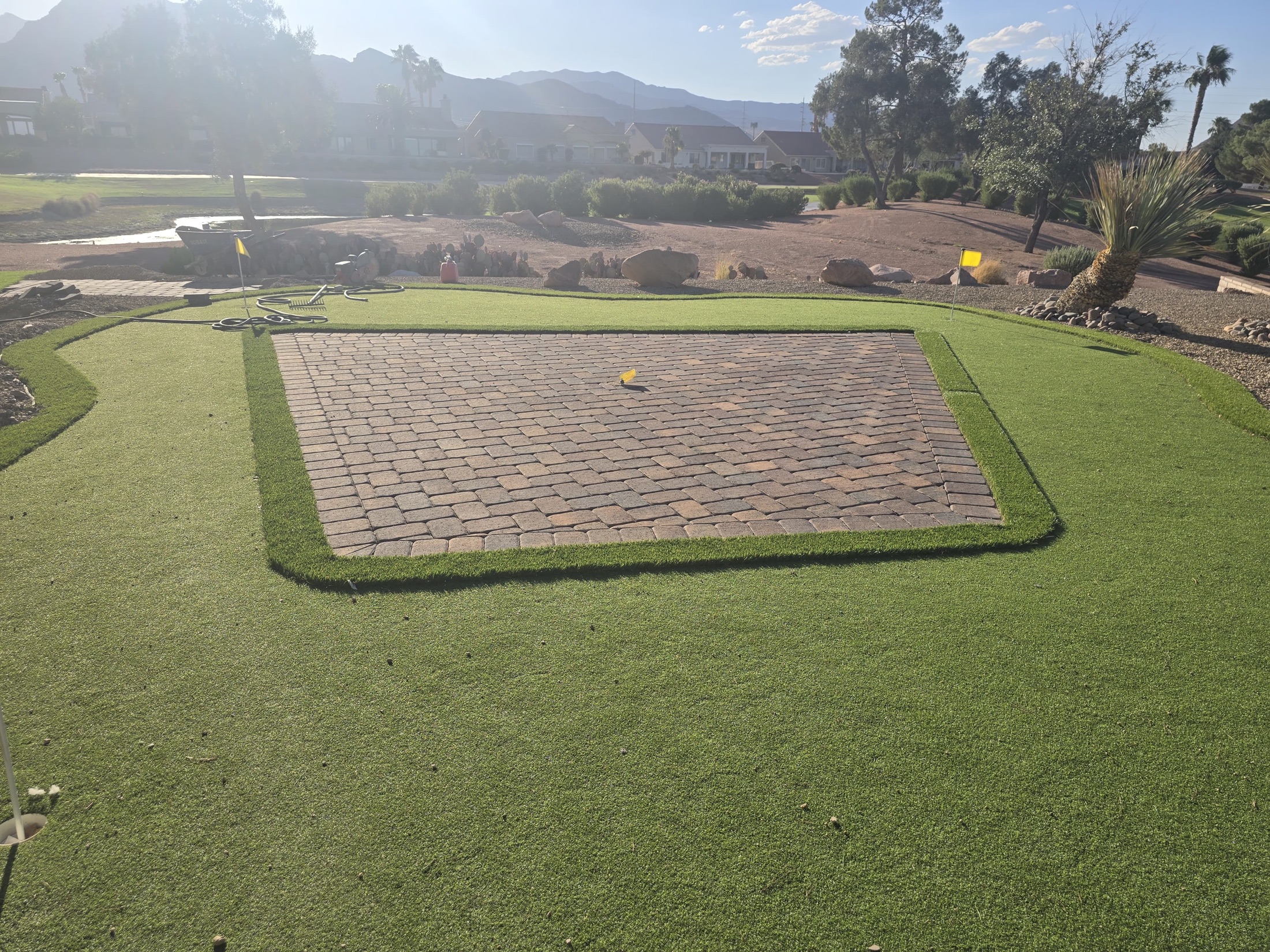 Paver sitting area surrounded by artificial turf with desert landscape and mountain view