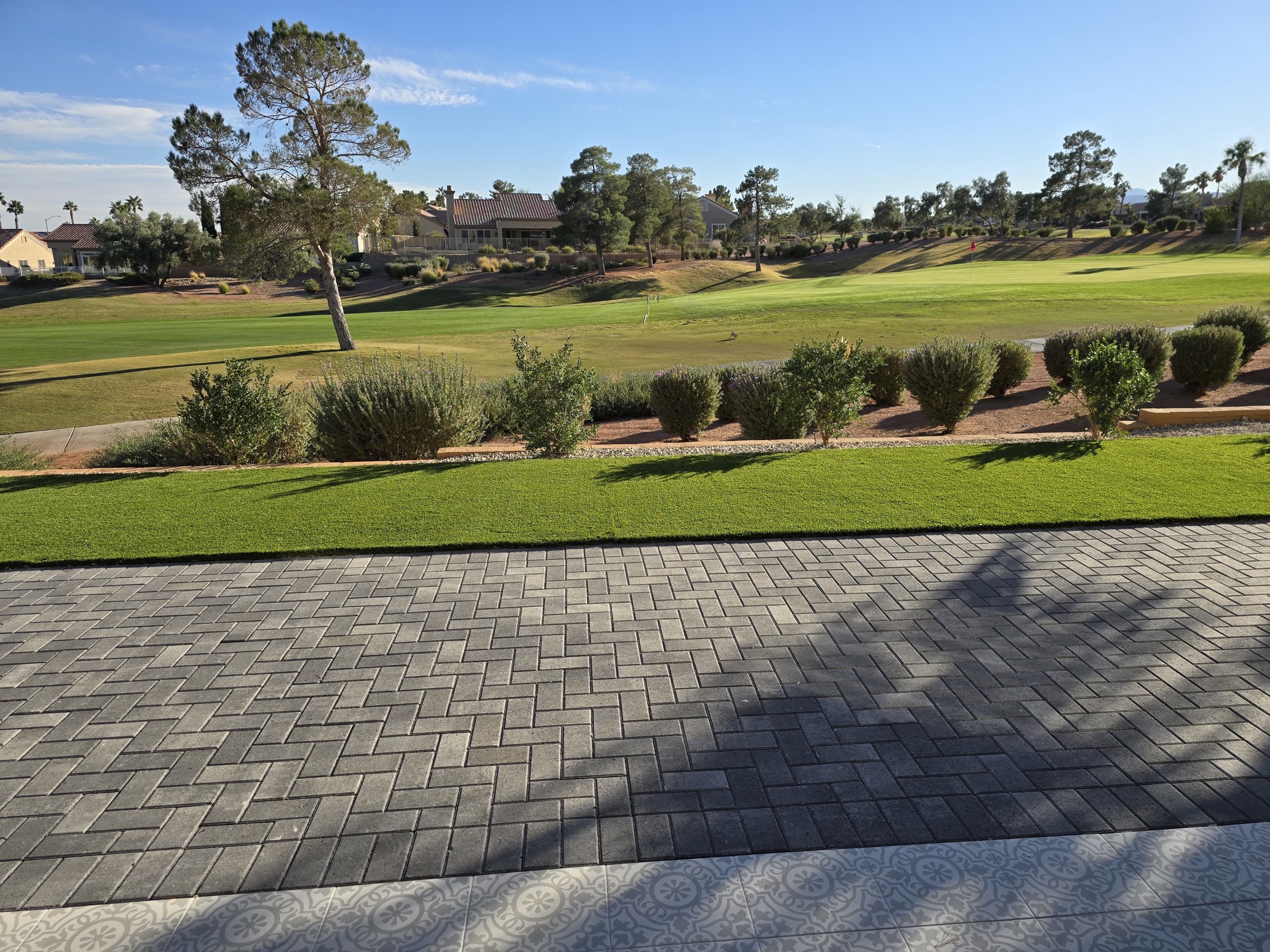 Finished gray paver patio beside artificial turf