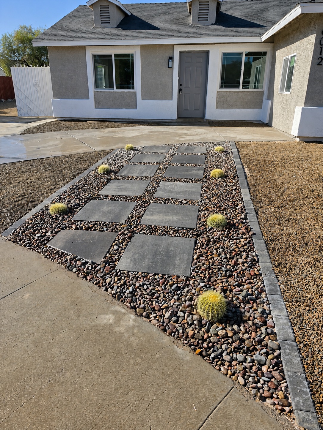 Stepping-stone entry path with decorative rock and cactus accents