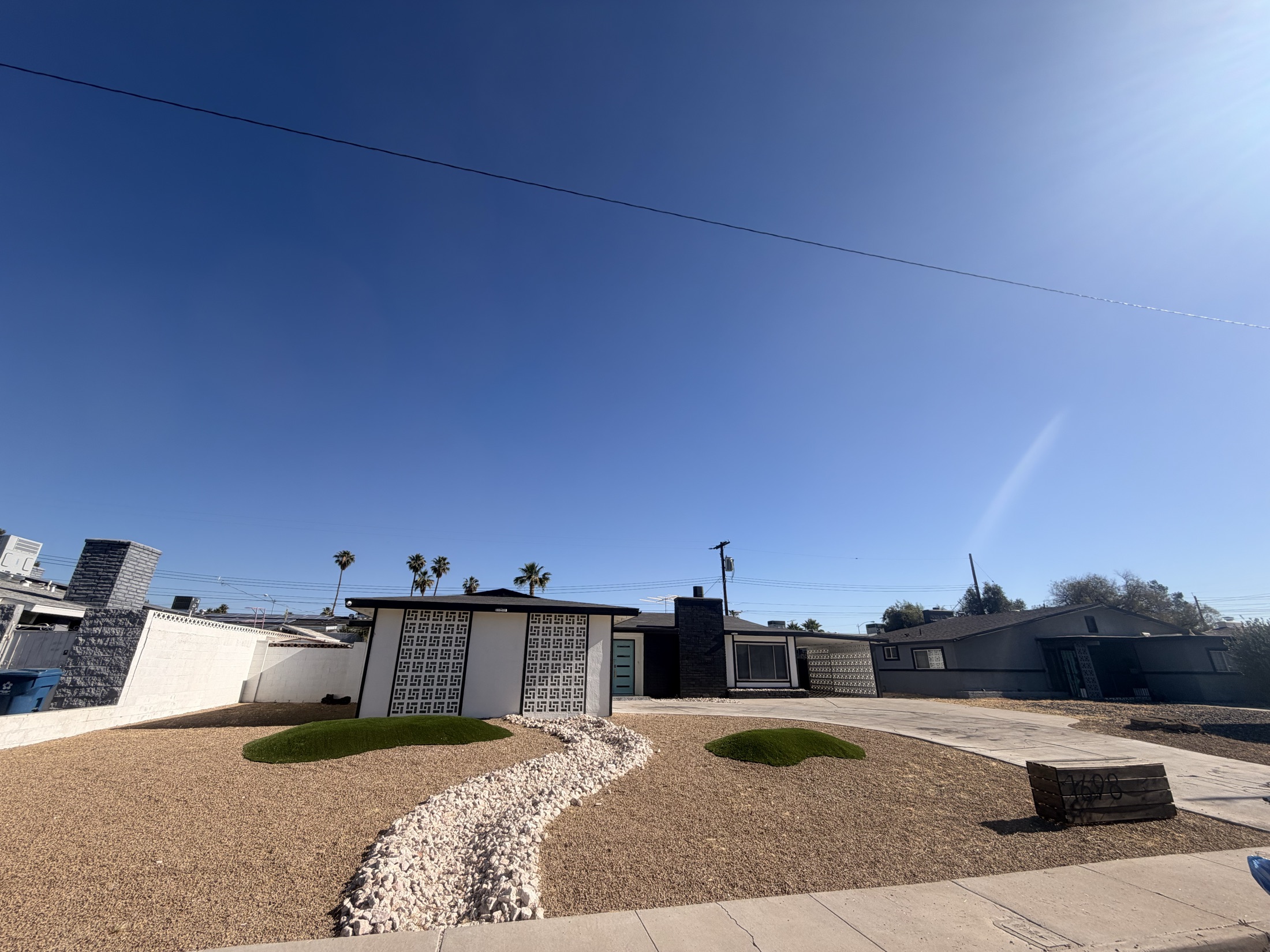 Desert landscape with decorative rock, boulder, tree lighting, and circular turf accent