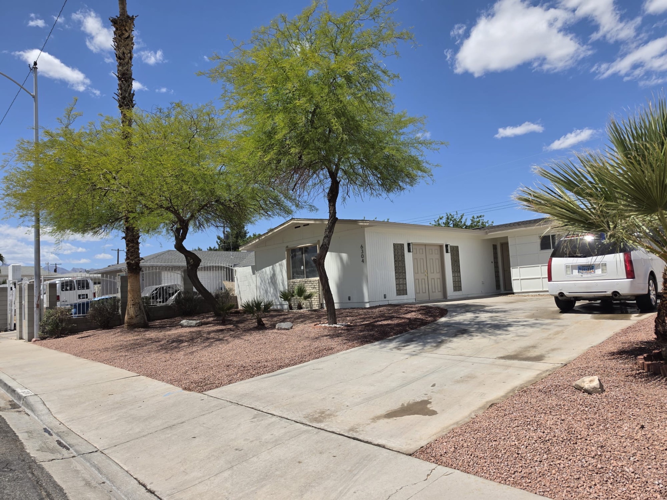 Two-story house with desert rock, boulders, yucca, and low-water front planting